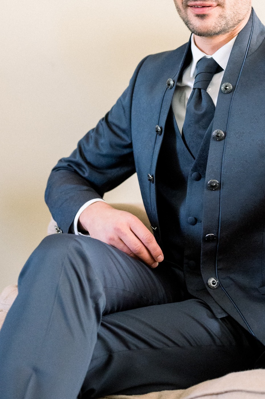 Stylish man in a navy blue suit sitting on a chair, looking dapper