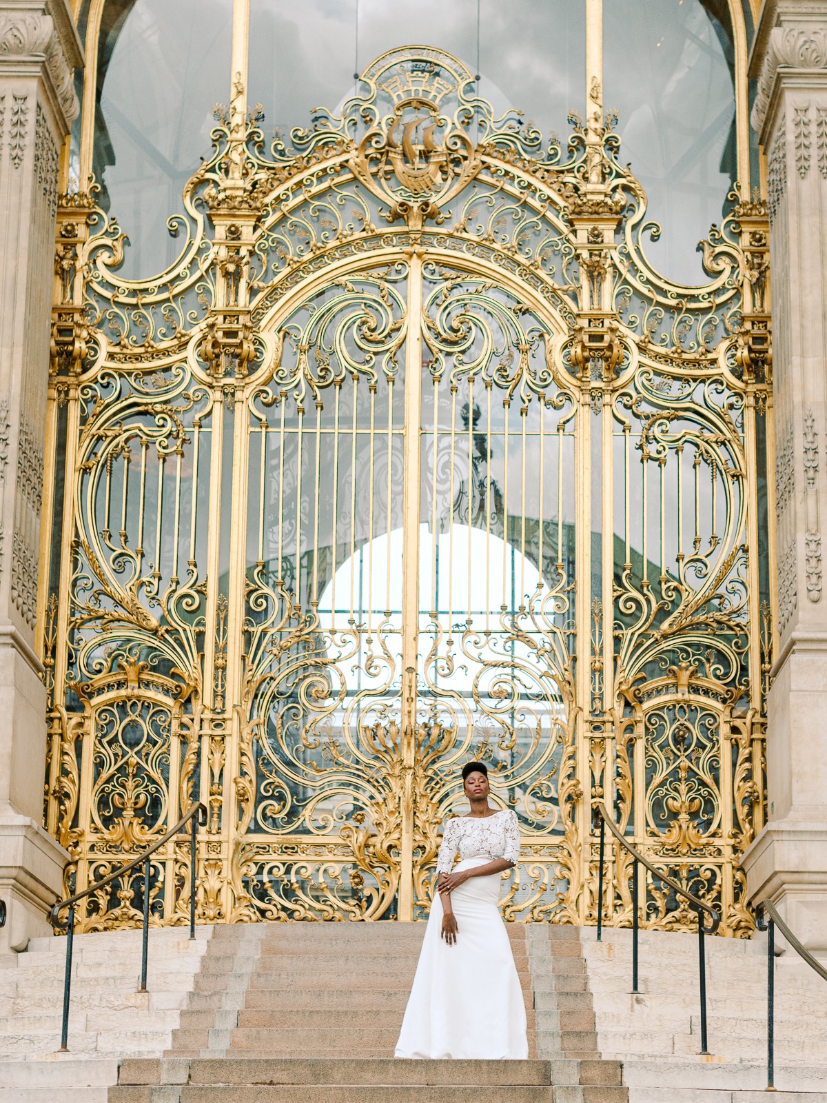 Bride posing in front of an ornate golden architectural entrance