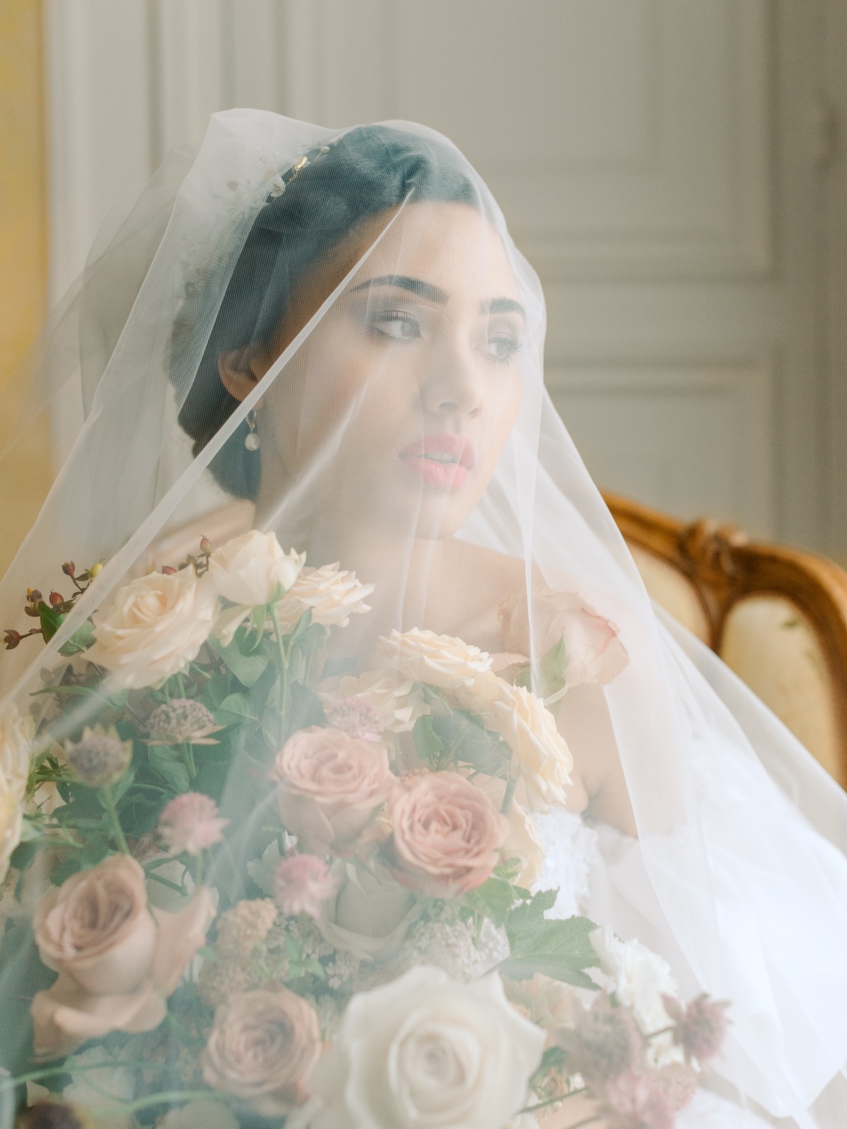 Bride veiled with flowers holding a bouquet looking elegant for wedding