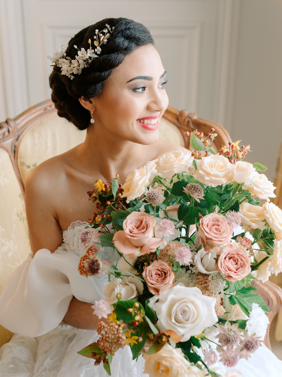 Beautiful bride smiles while holding a lovely floral bouquet