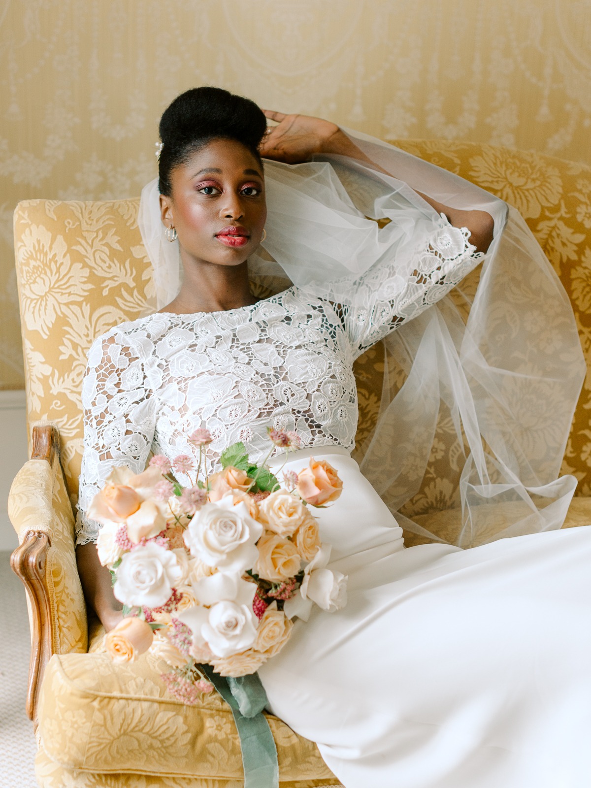 Elegant bride in lace dress and flowers, looking at the camera