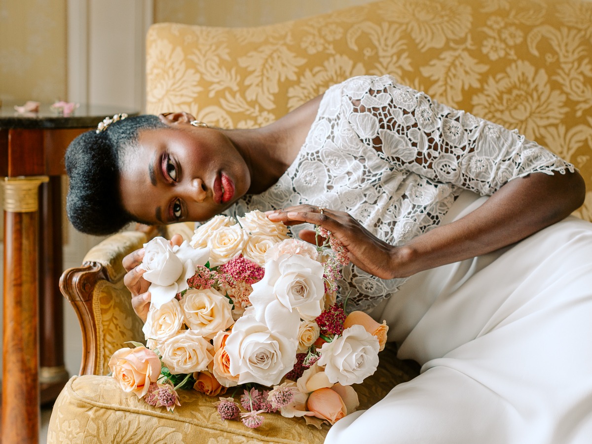 Elegant bride with a bouquet posing on a vintage chair