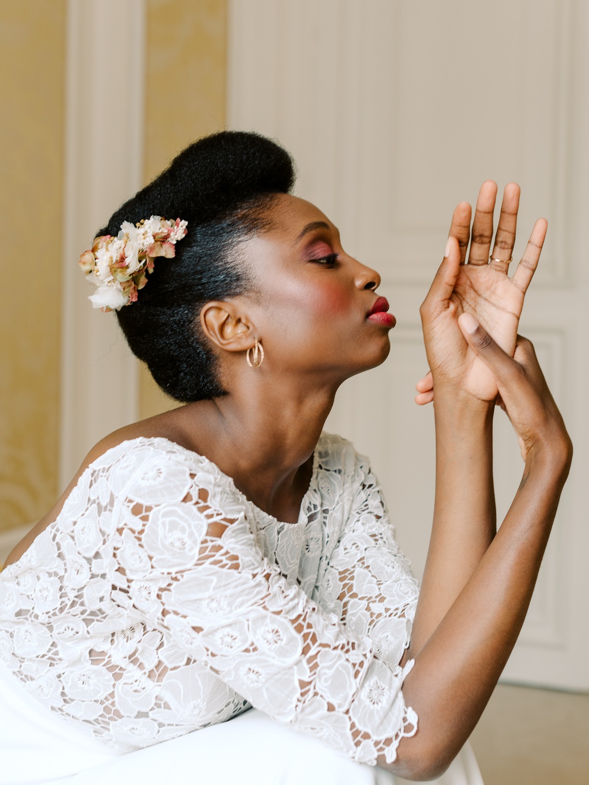 Elegant bride with flowers in her hair, lace top and graceful hands