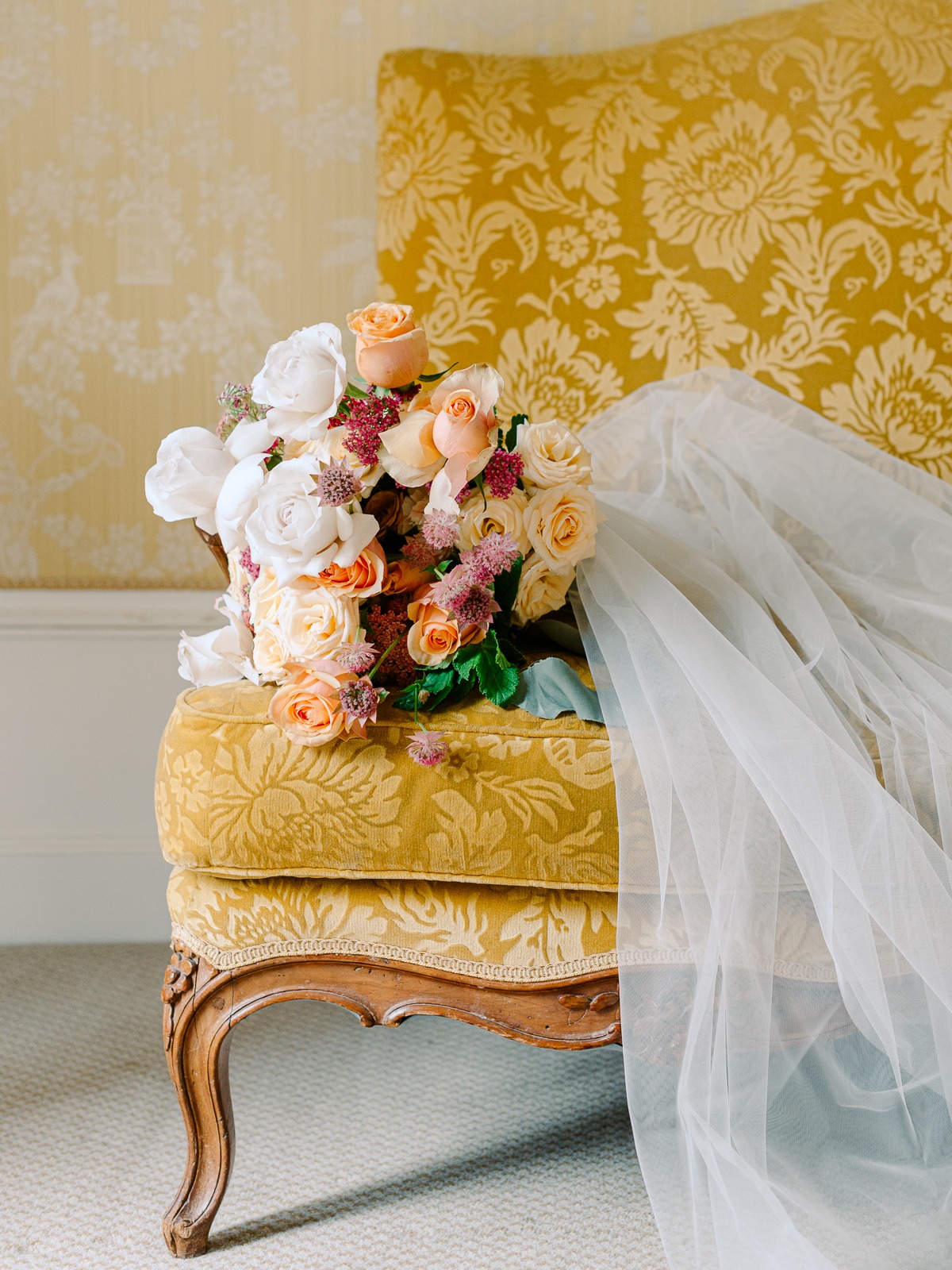 Elegant floral bouquet on a vintage yellow chair with veil