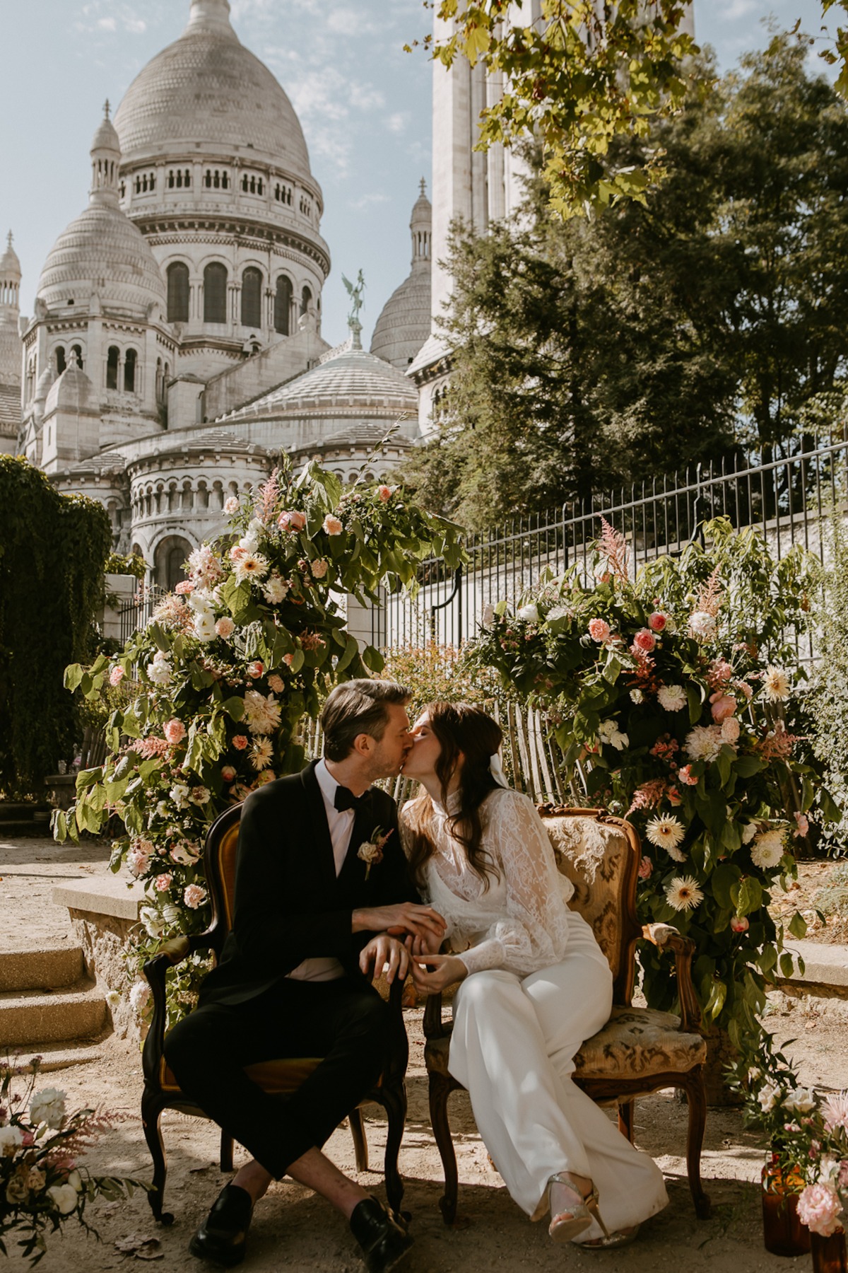 Couple kisses at wedding ceremony in front of Sacre Coeur in Paris