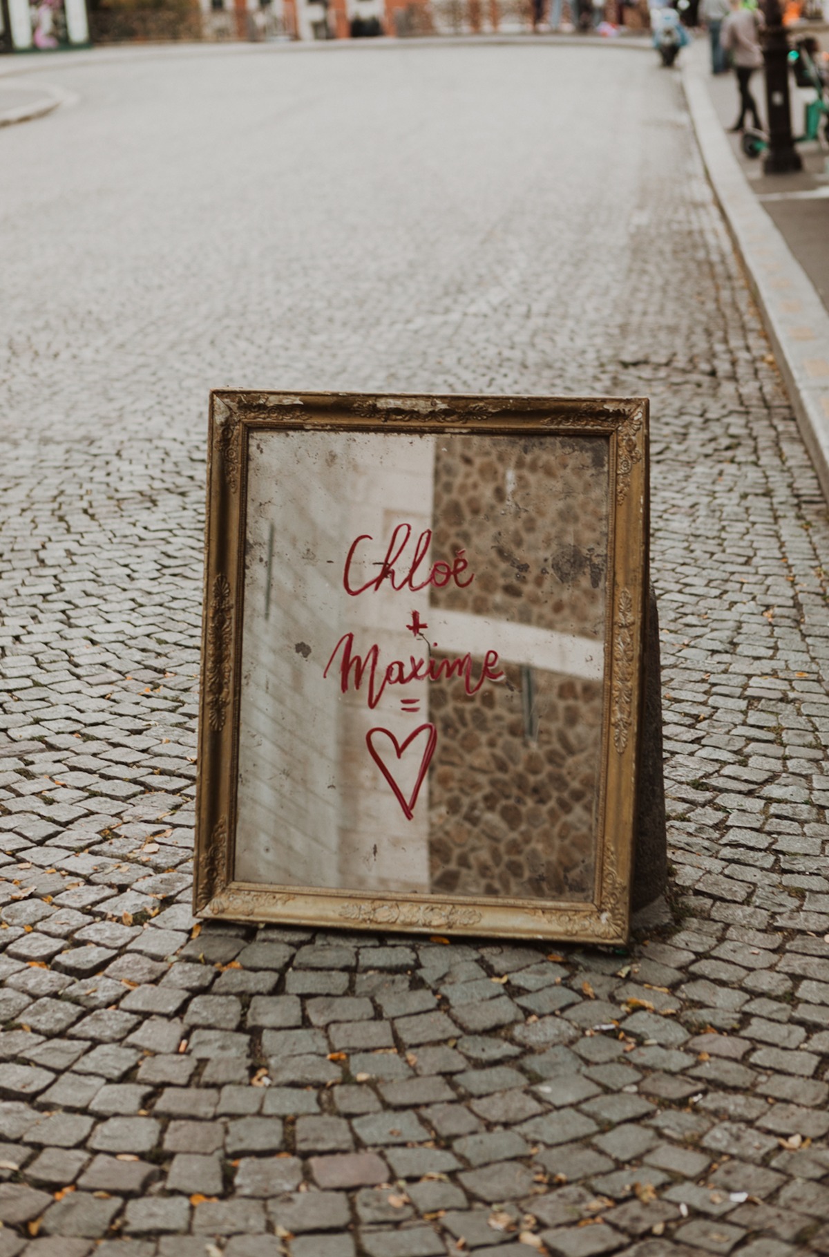 Mirror sign with Chloe and Maxime and a heart, on cobblestone street