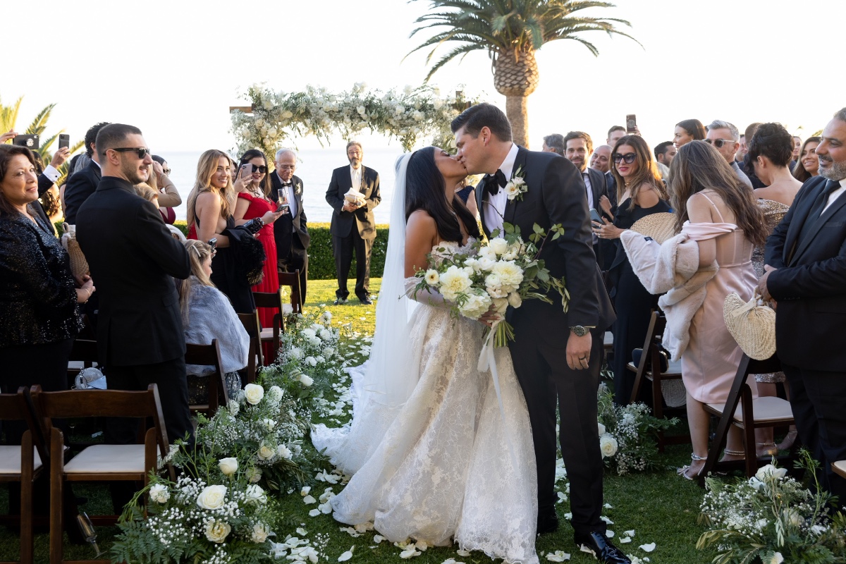 Bride and groom share a kiss at their romantic outdoor wedding