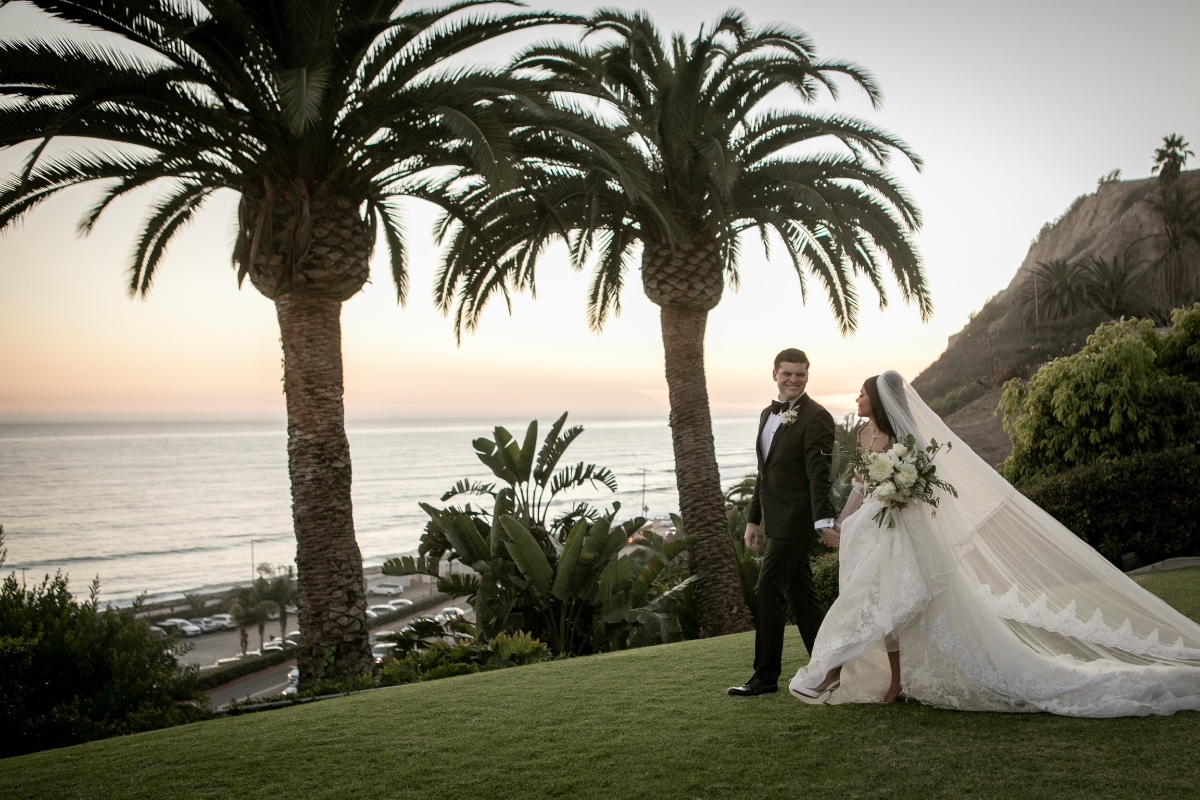 Bride and groom walking together at a beautiful oceanfront wedding ceremony