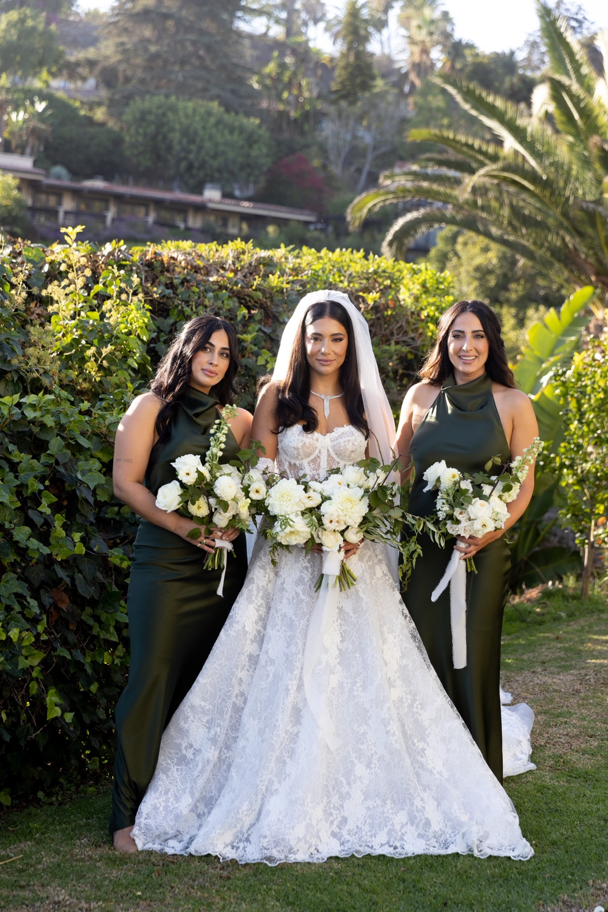 Bride with bridesmaids in green at an outdoor wedding