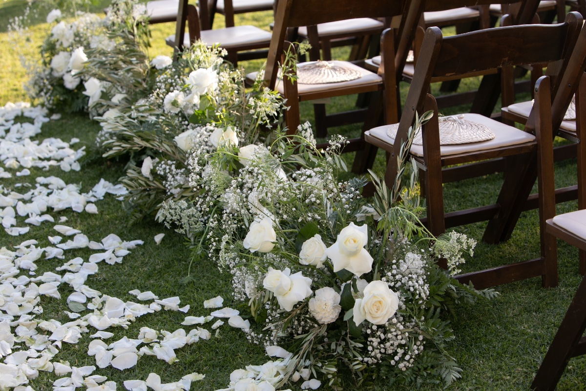Wedding ceremony with white roses and petal strewn aisle