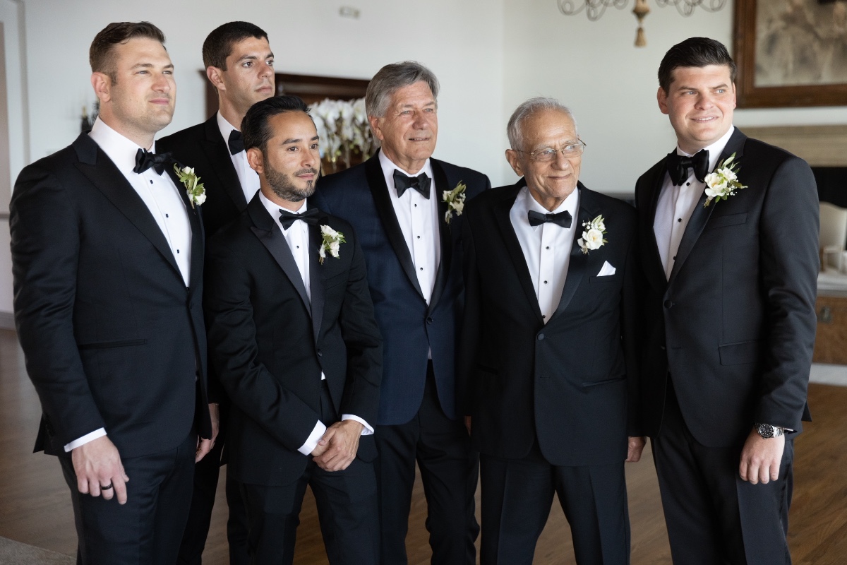 Men in tuxedos posing for a formal wedding picture