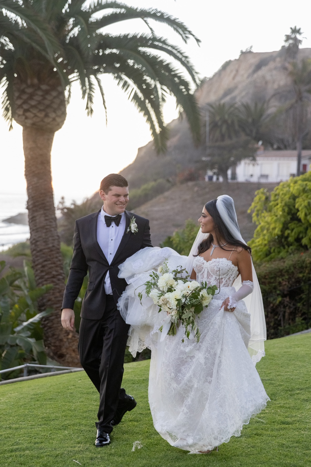 Bride and groom walking together on the grass at their wedding