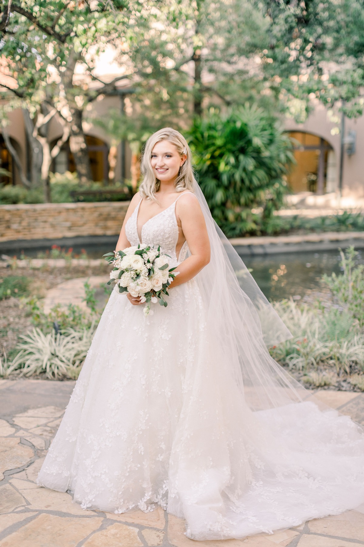 Blonde bride in wedding dress holding white bouquet