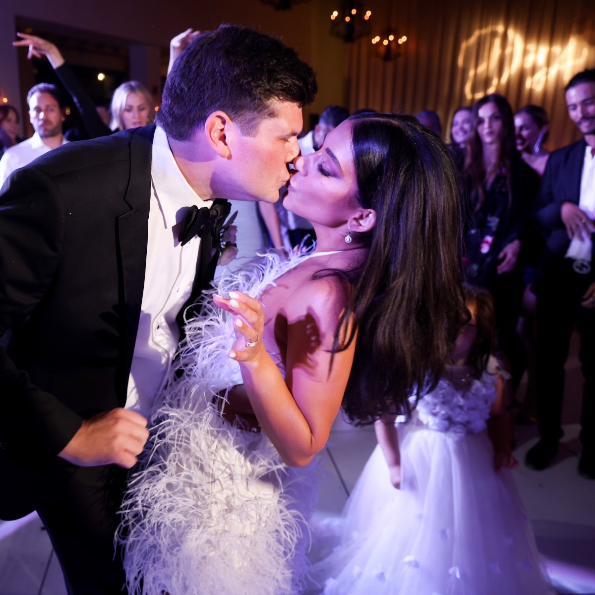 Newlyweds share a passionate kiss at their wedding reception