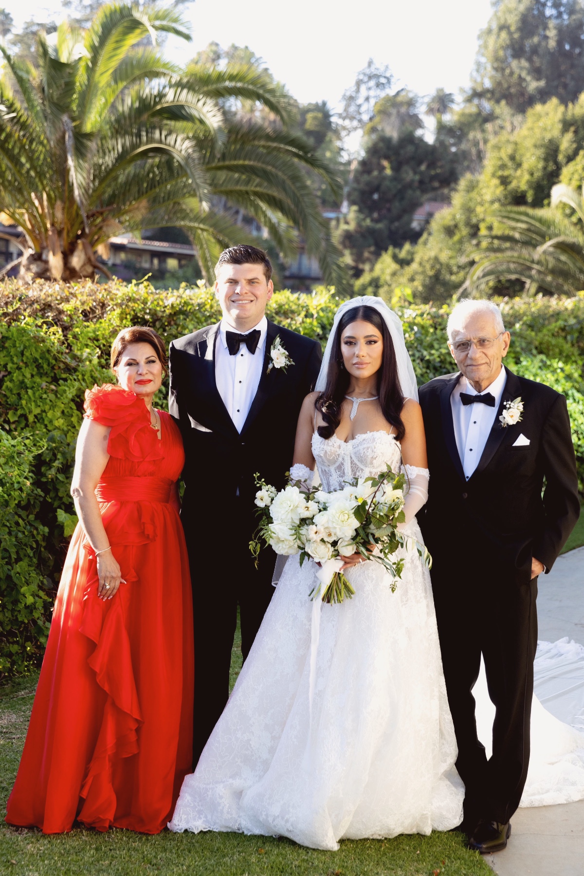 Family posing together at an outdoor wedding ceremony with bride