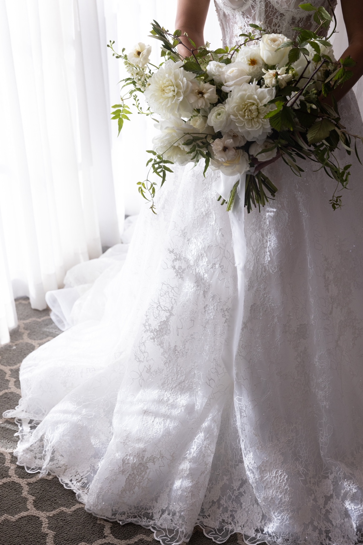 Elegant bride with white floral bouquet and lace wedding dress