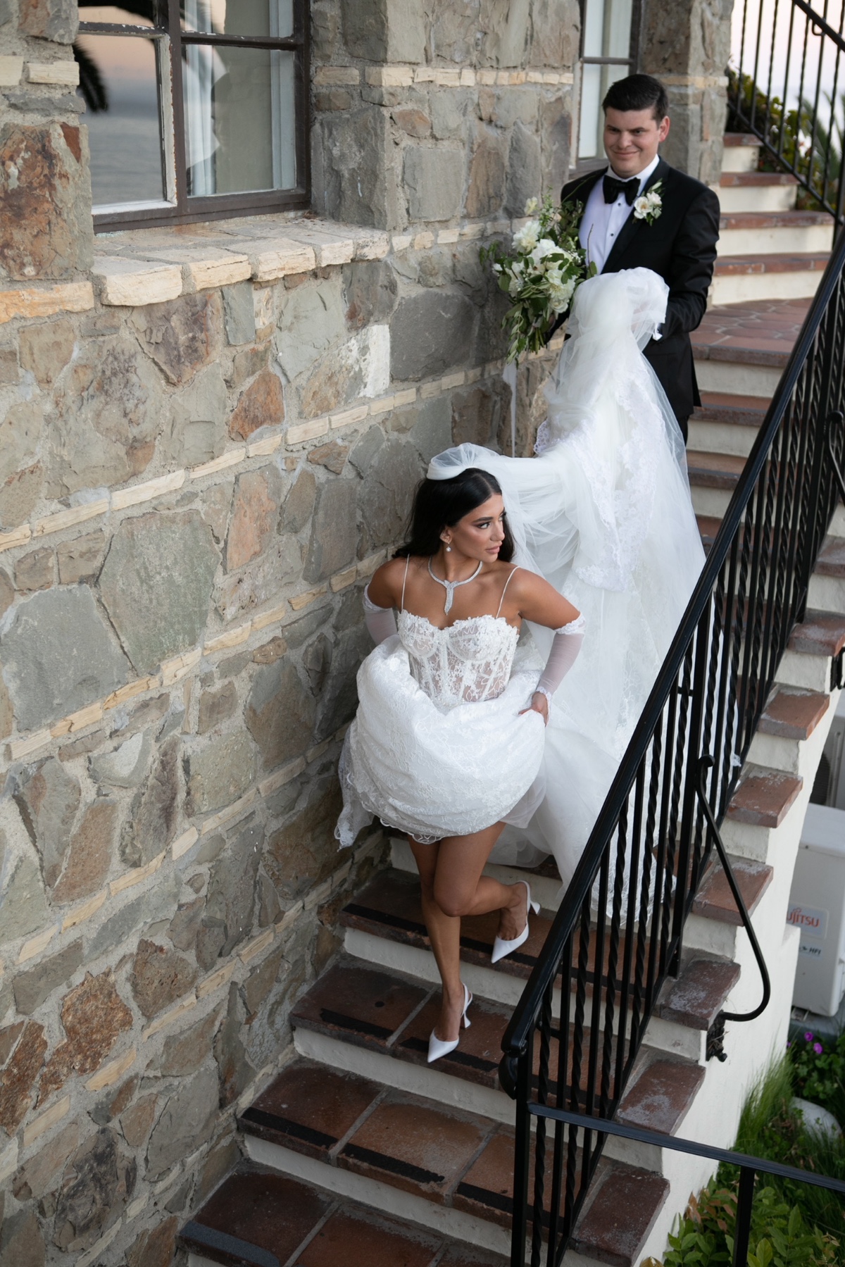 Bride descending stairs with groom at a wedding ceremony