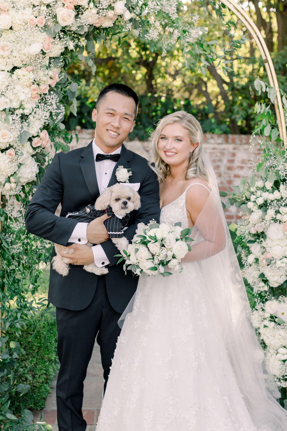 Bride groom and dog at their outdoor wedding ceremony