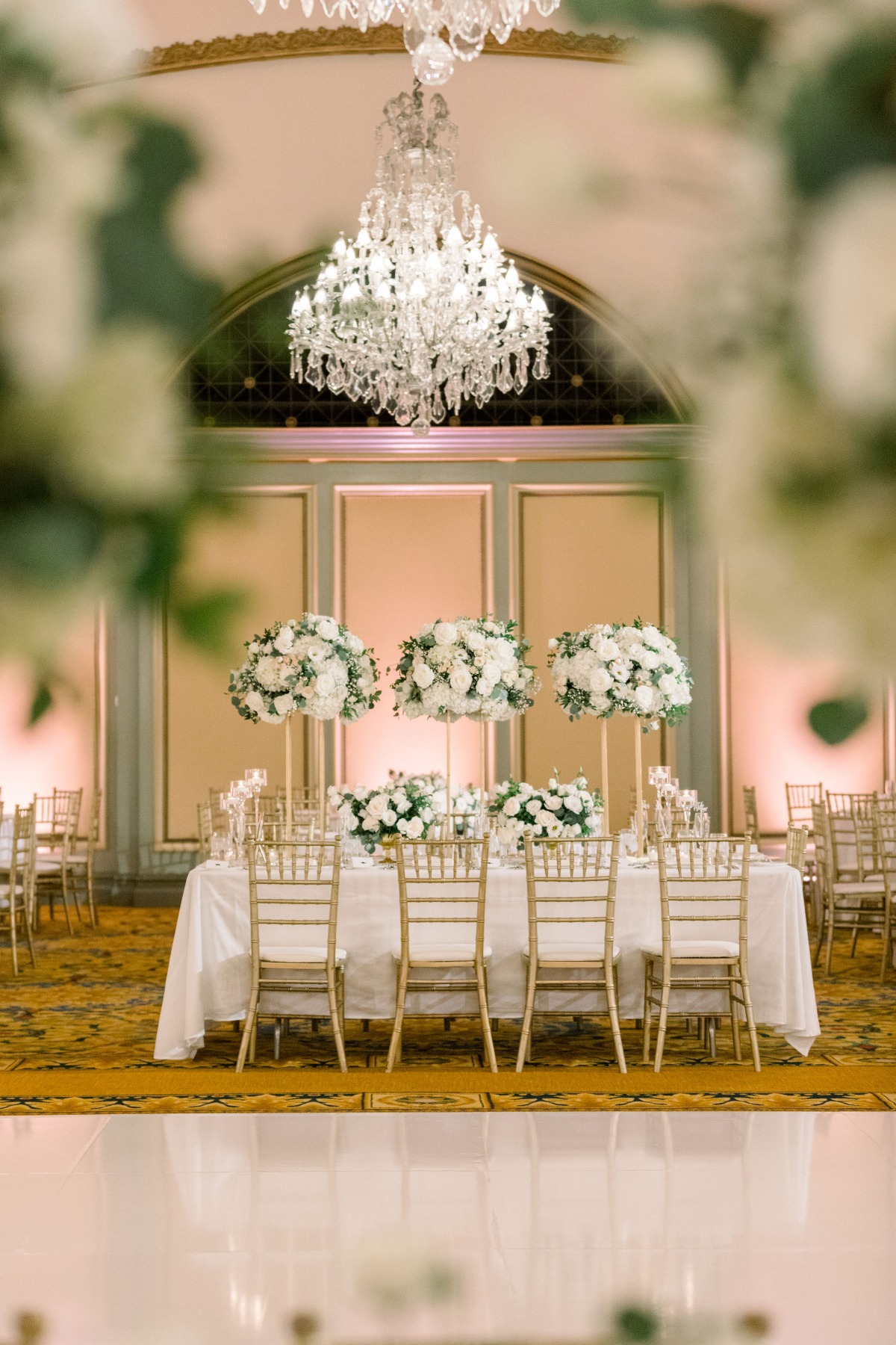 Elegant wedding reception with chandelier and floral centerpieces