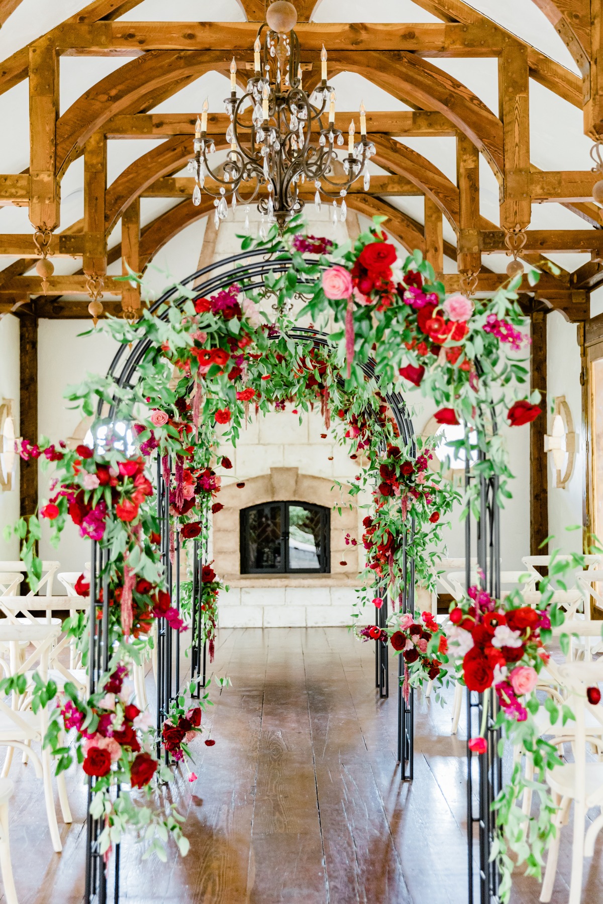 Elegant wedding archway decorated with vibrant red flowers