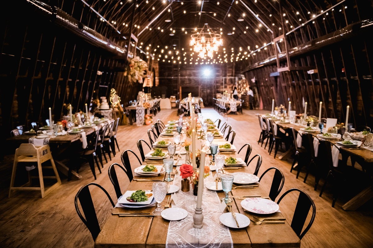 Elegant wedding reception tables set in a rustic barn venue