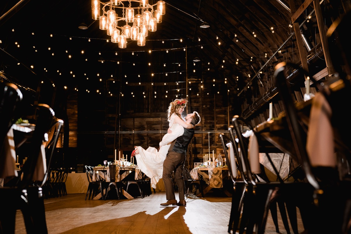 Romantic wedding dance in a rustic barn with elegant lighting