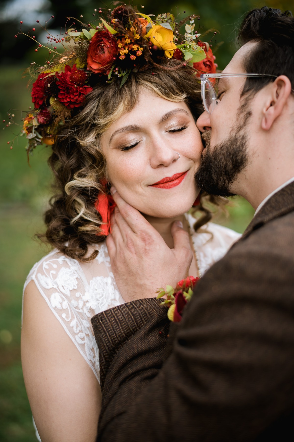 Bride and groom share a loving kiss on wedding day with floral crown