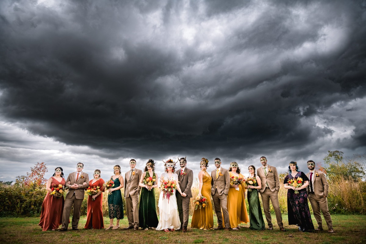 Wedding party poses under dramatic, dark storm clouds