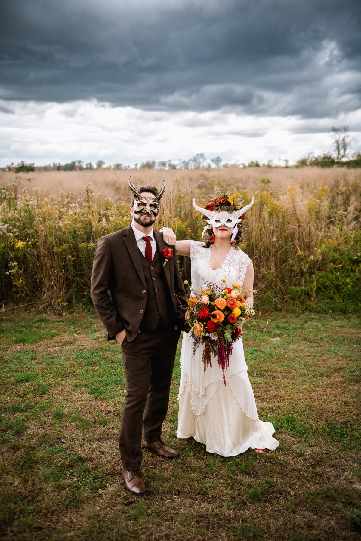 Unique couple in masks pose for a moody wedding photoshoot in nature