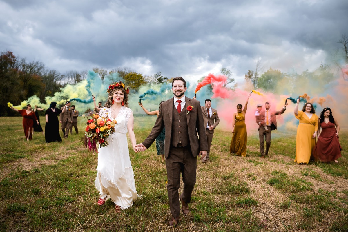 Happy wedding couple with colorful smoke grenades celebration