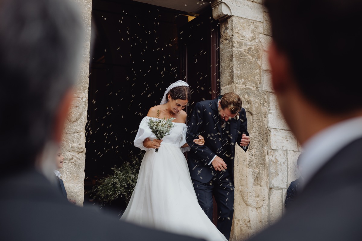 Newlyweds showered with confetti exiting church on wedding day