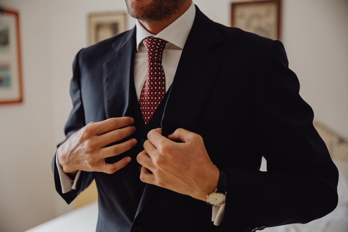 Groom adjusting his suit and tie before a special event or celebration