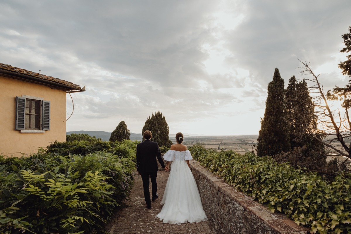 Newlyweds stroll hand-in-hand at a scenic wedding location