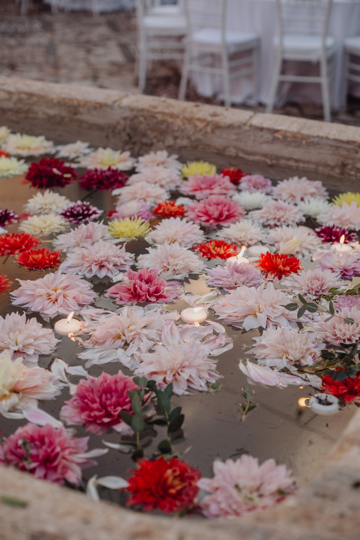 Floating dahlias and candles in water for a beautiful wedding setting