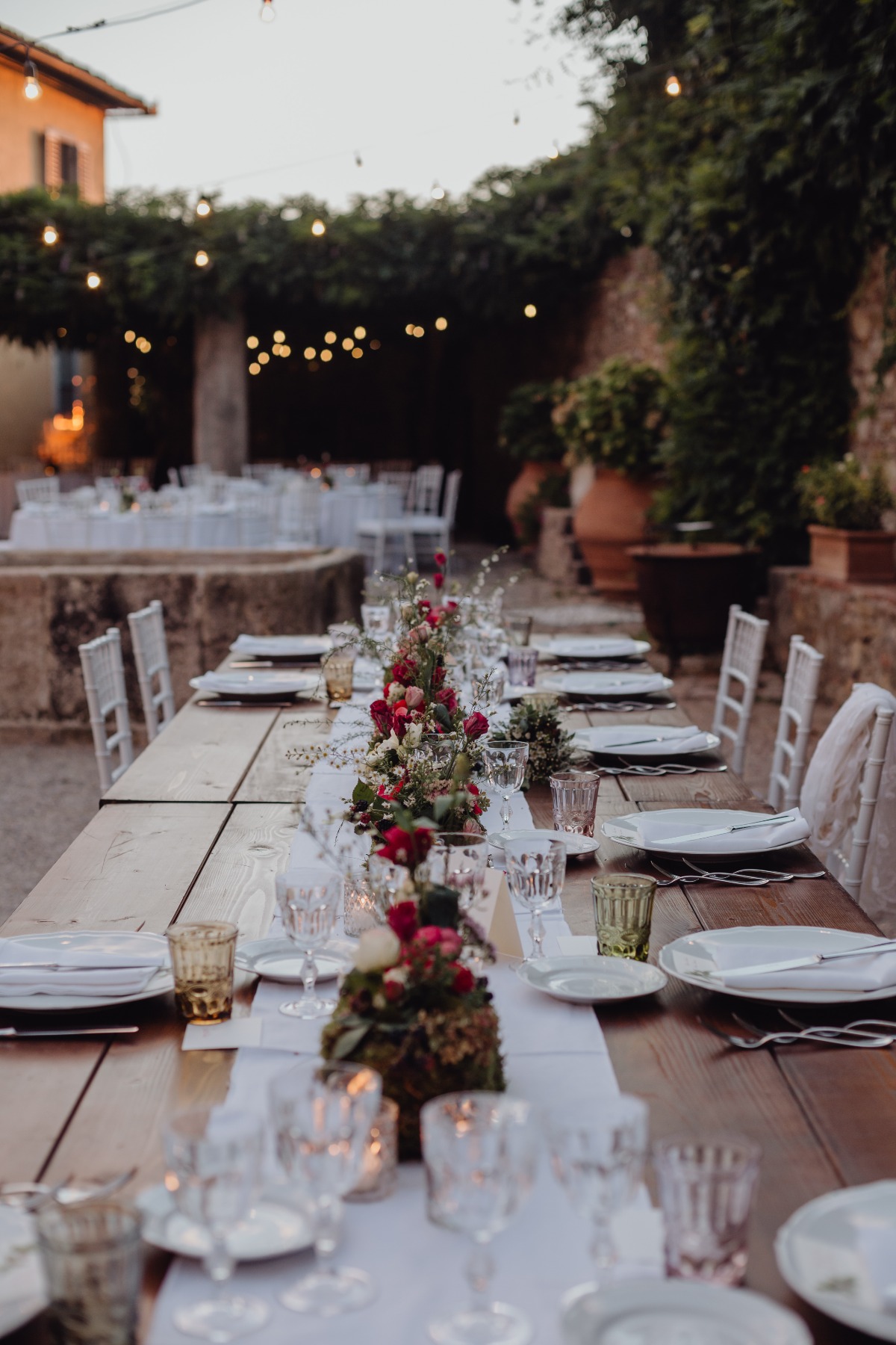 Wedding reception table set outdoors with floral centerpiece
