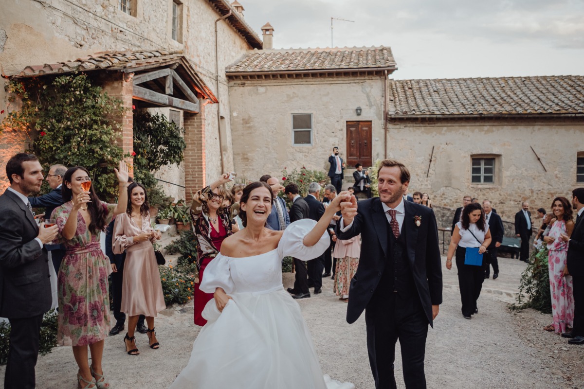 Newlyweds celebrate their wedding, surrounded by joyful guests and old buildings
