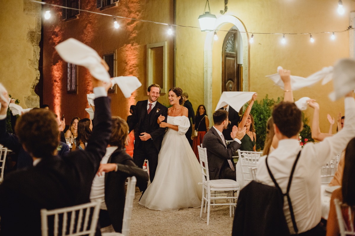 Newlyweds greeted by guests waving handkerchiefs at wedding reception