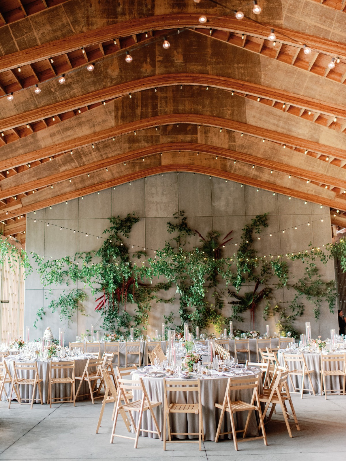 Elegant wedding reception with greenery and wooden beams