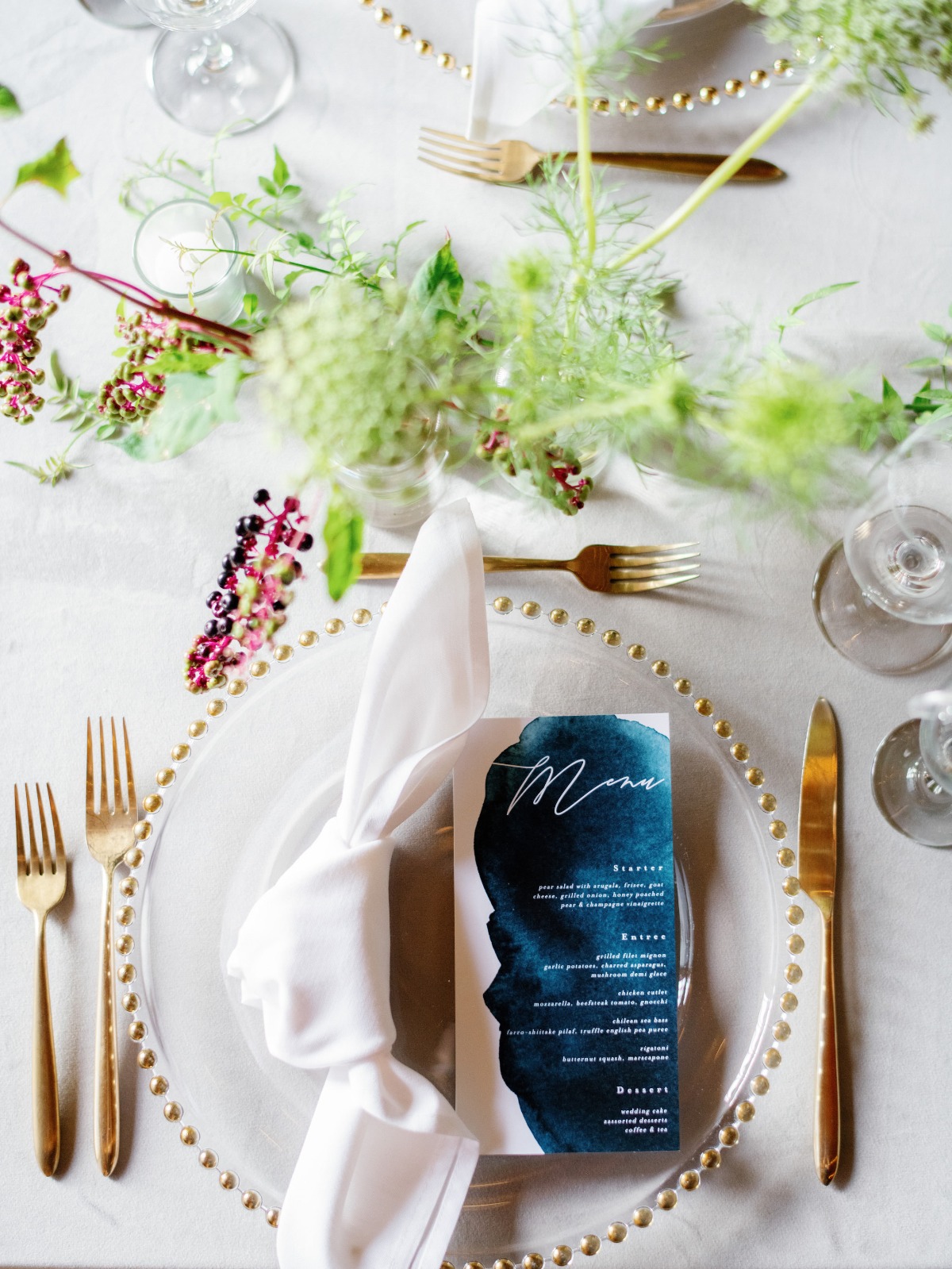 Elegant wedding place setting with a menu and gold flatware