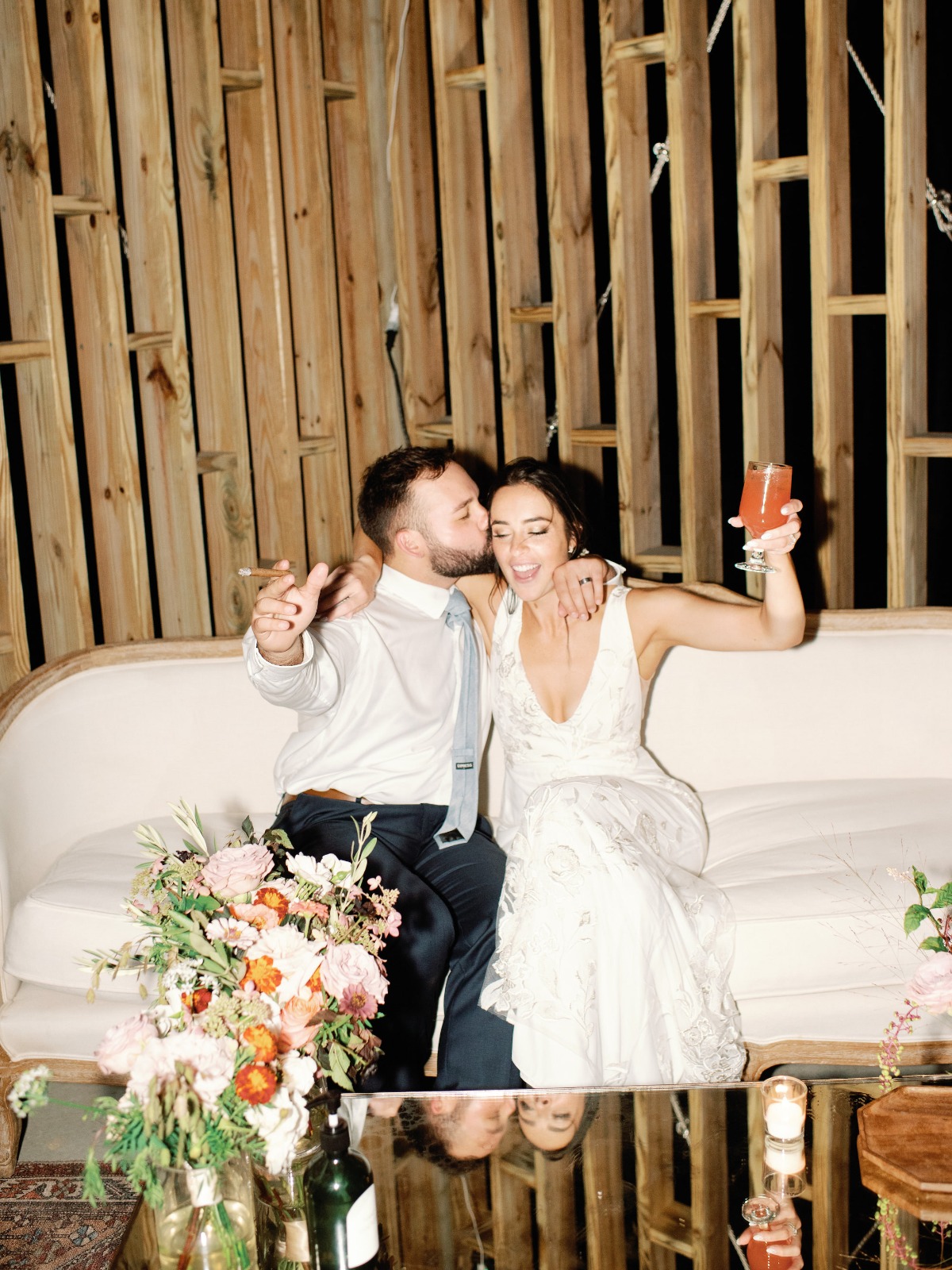 Bride and groom celebrating wedding with a toast and kiss
