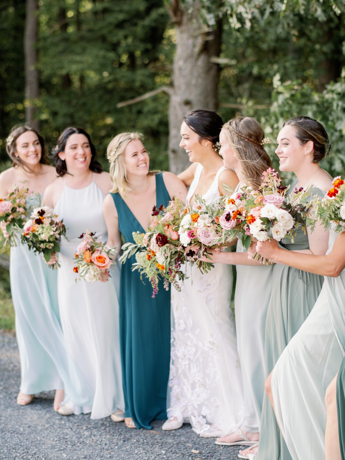 Bride and bridesmaids in gowns holding wedding bouquets