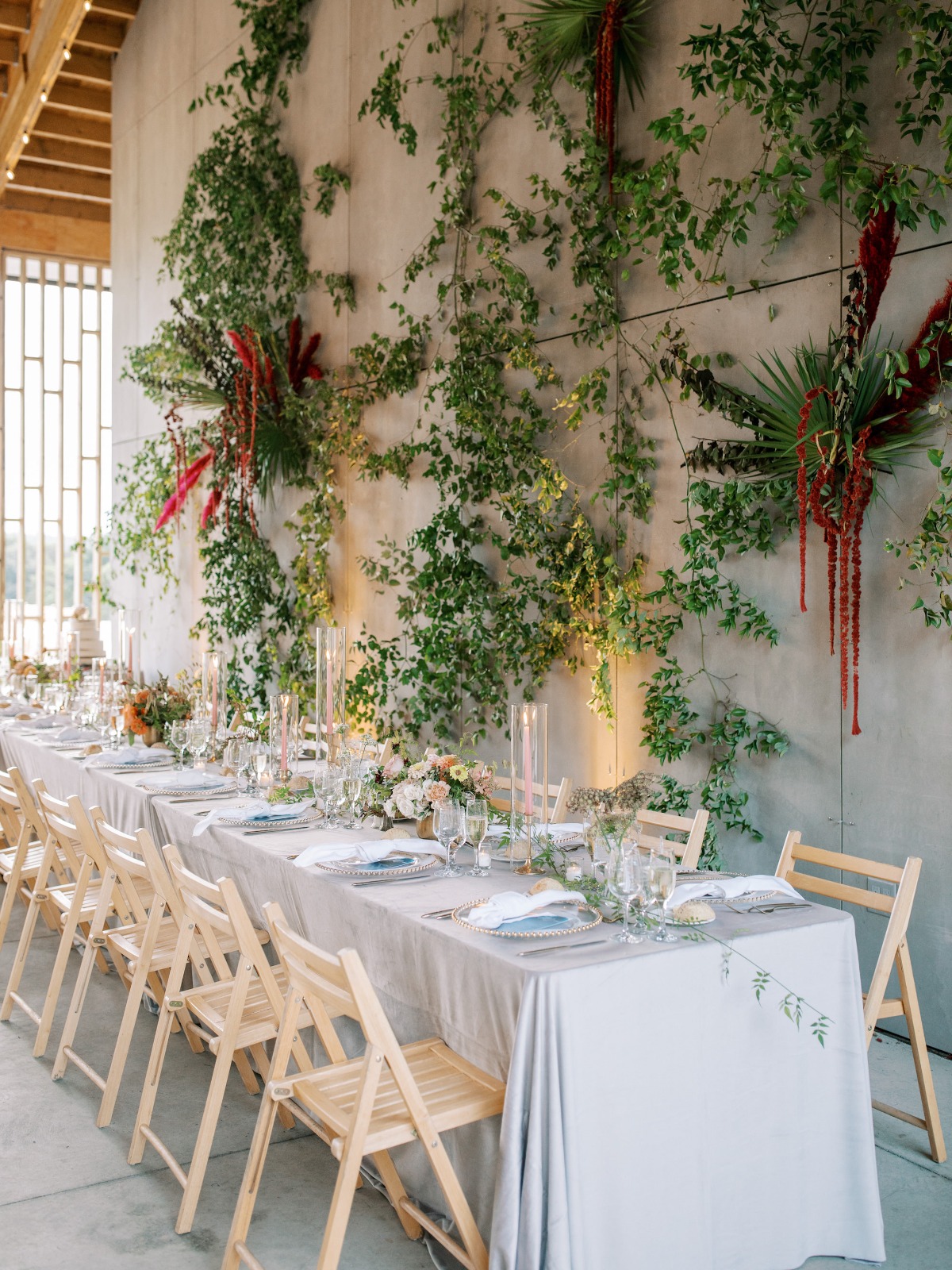 Elegant wedding table setting with lush floral wall decor