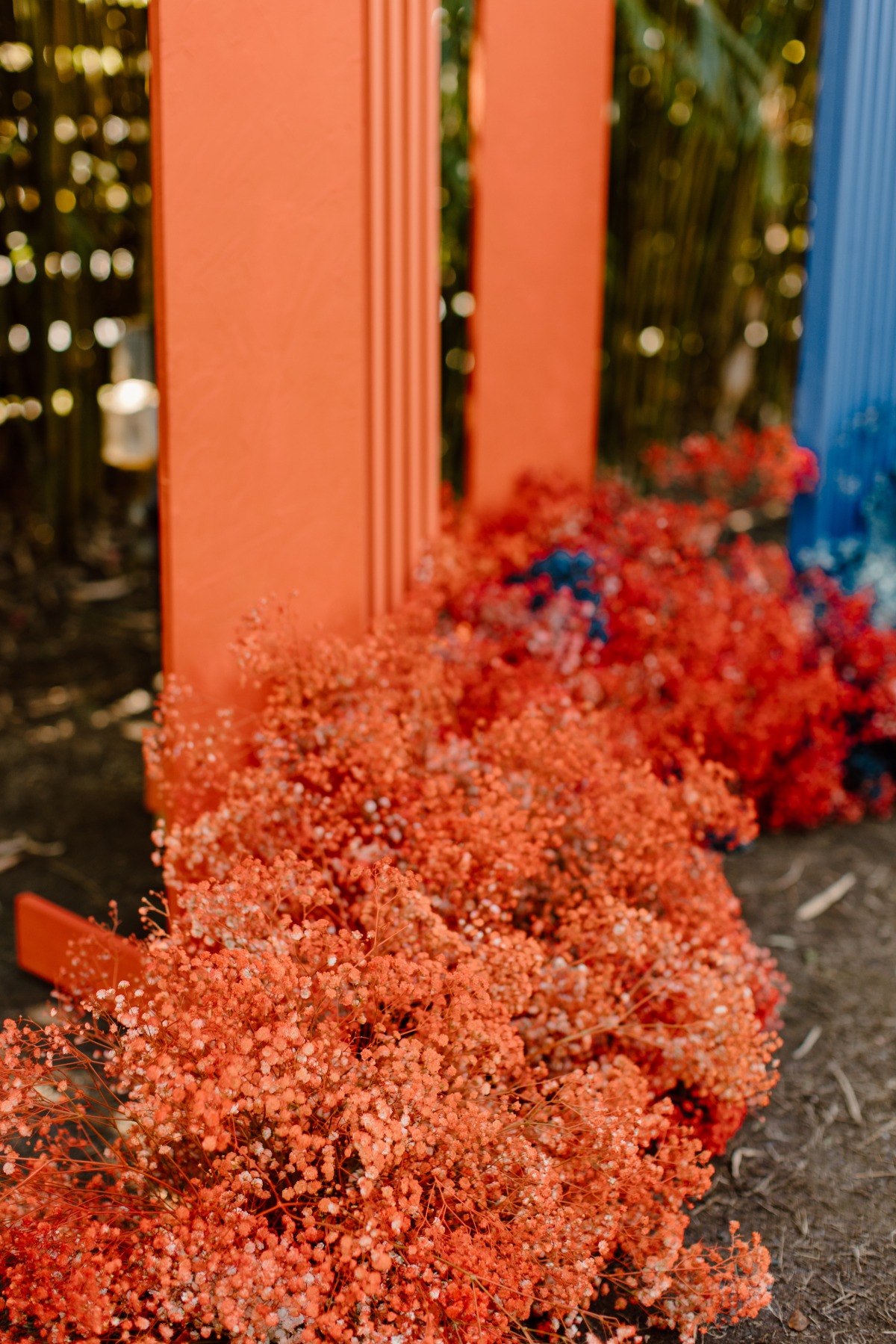 Floral display with orange and blue pillars backdrop