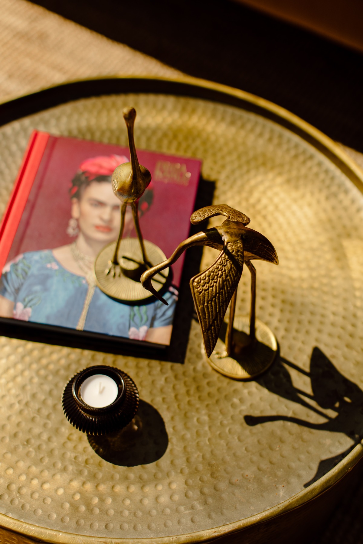 Brass bird figurines on a tray with a book