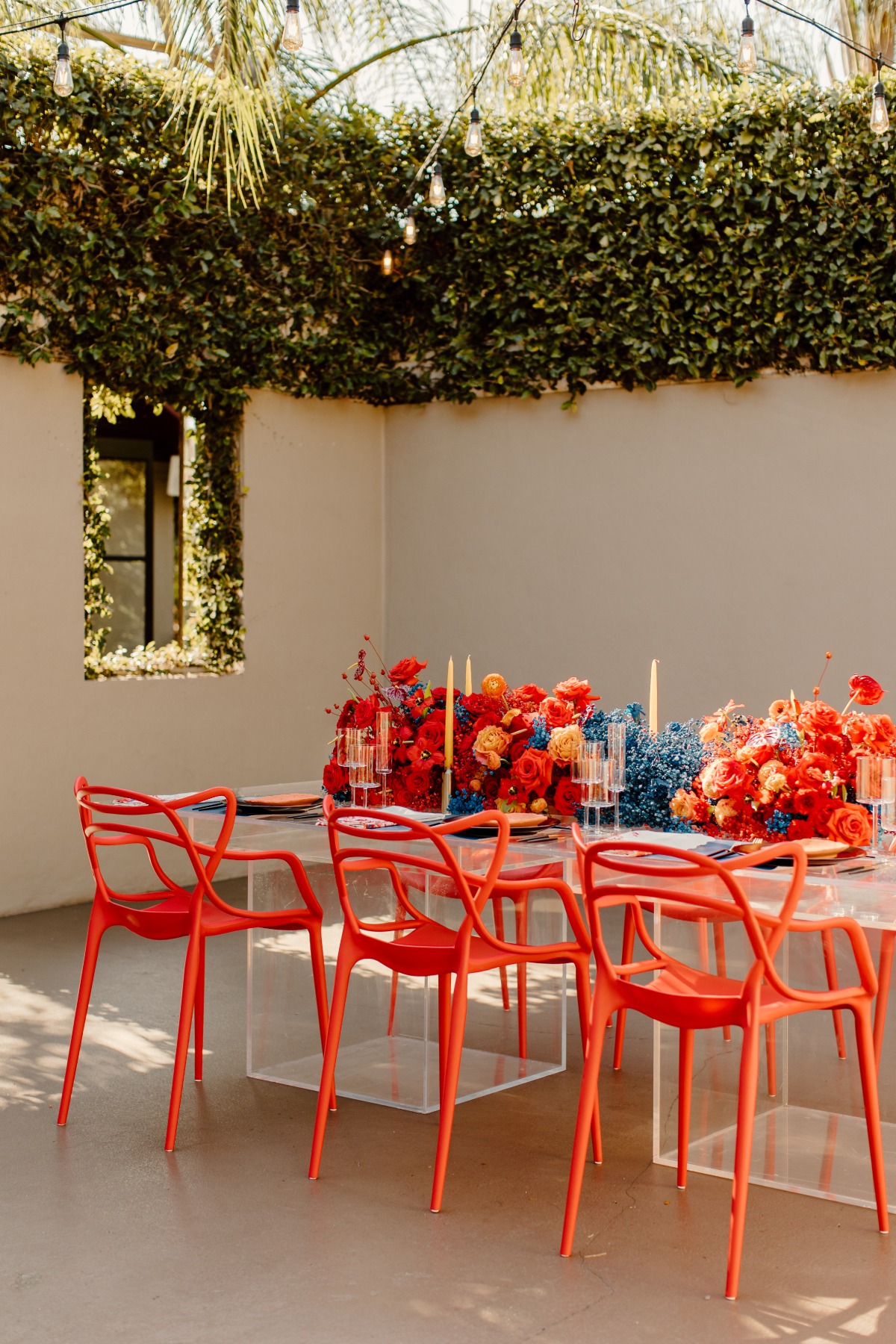 Outdoor event with bright florals and orange chairs