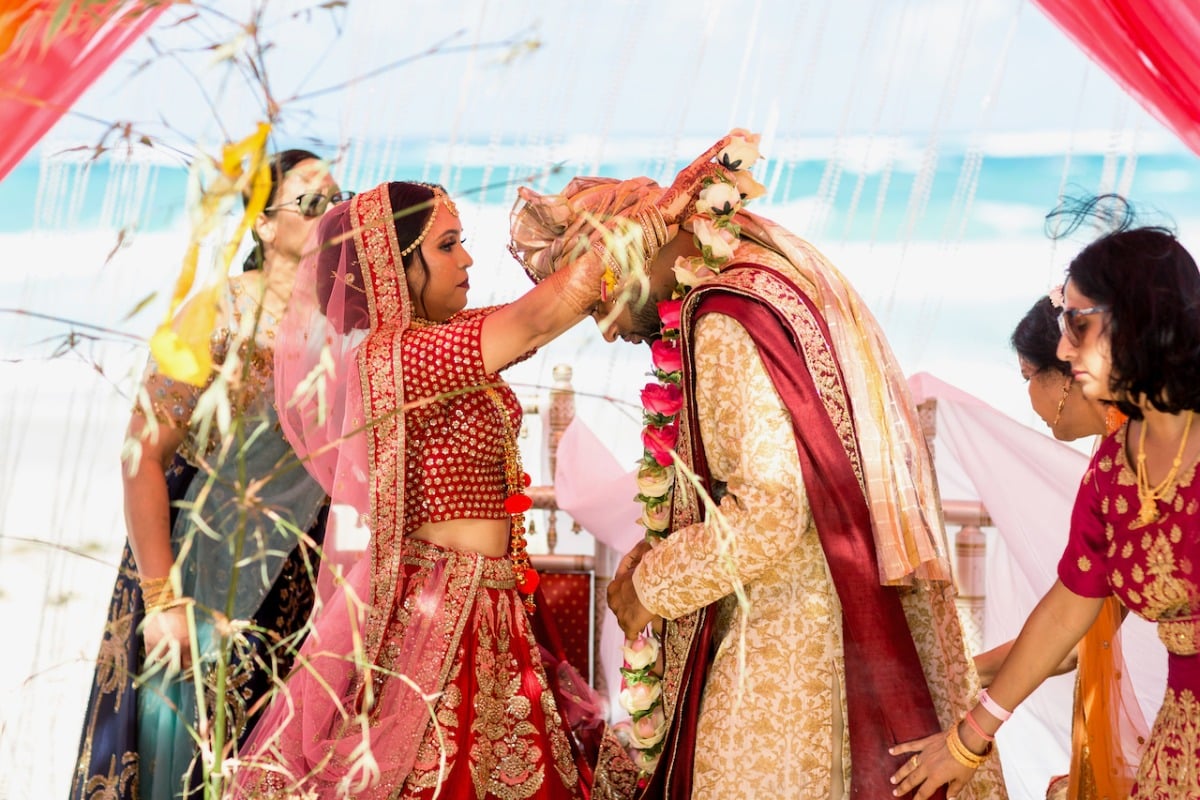 Bride placing floral garland over groom in traditional Hindu ceremony