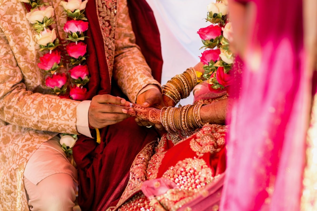 Groom placing ring on bride's hand during ceremony