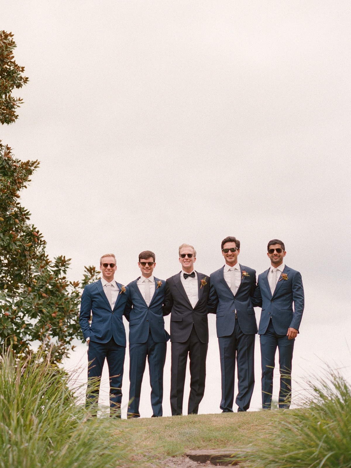 Portrait of groom and groomsmen on top of hill