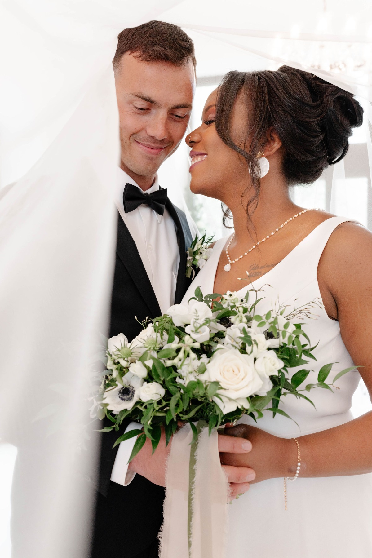 Portrait of bride and groom under veil