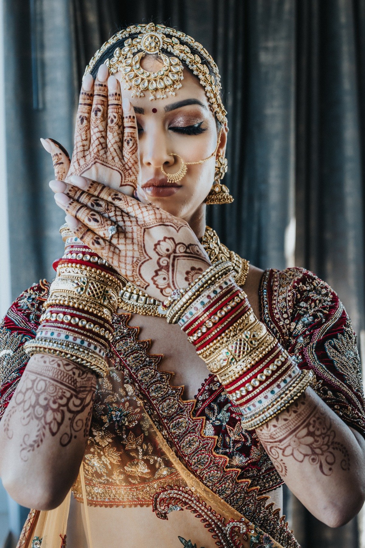 6The bride holding up arms covered in henna and bracelets showing engagement ring